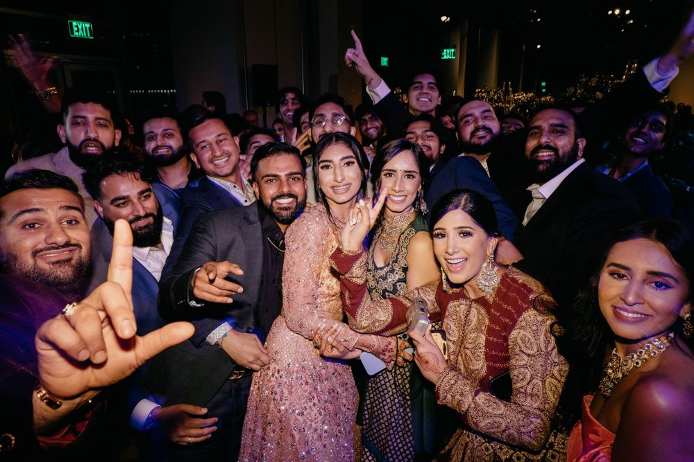 Nighttime wedding reception with people dancing and celebrating.