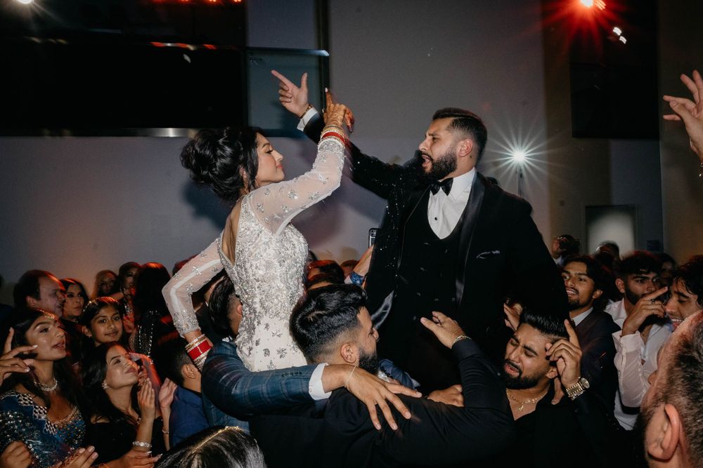 Energetic crowd dancing and celebrating at a lively indoor party with colorful lighting effects.