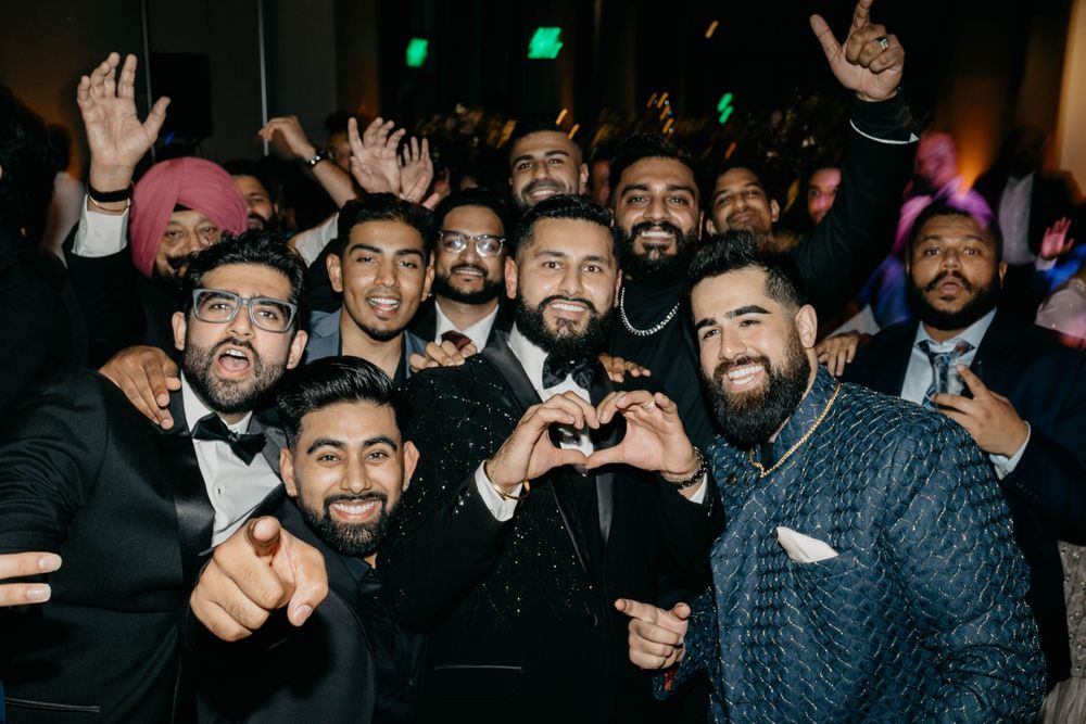 Enthusiastic partygoers gesturing and celebrating in formal attire at a nighttime event.