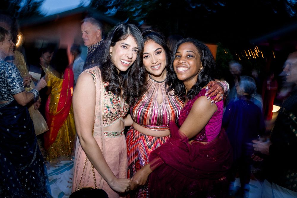 Group of friends dancing and enjoying themselves at a nighttime celebration event.