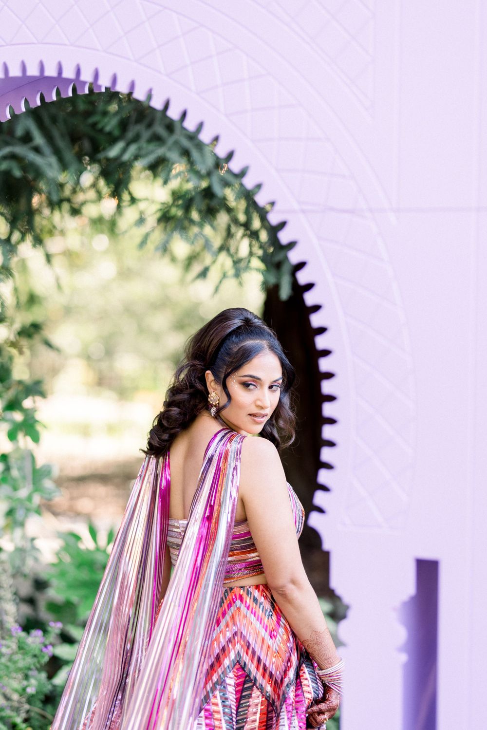 A striped dress with flowing fabric photographed under white architectural arches.