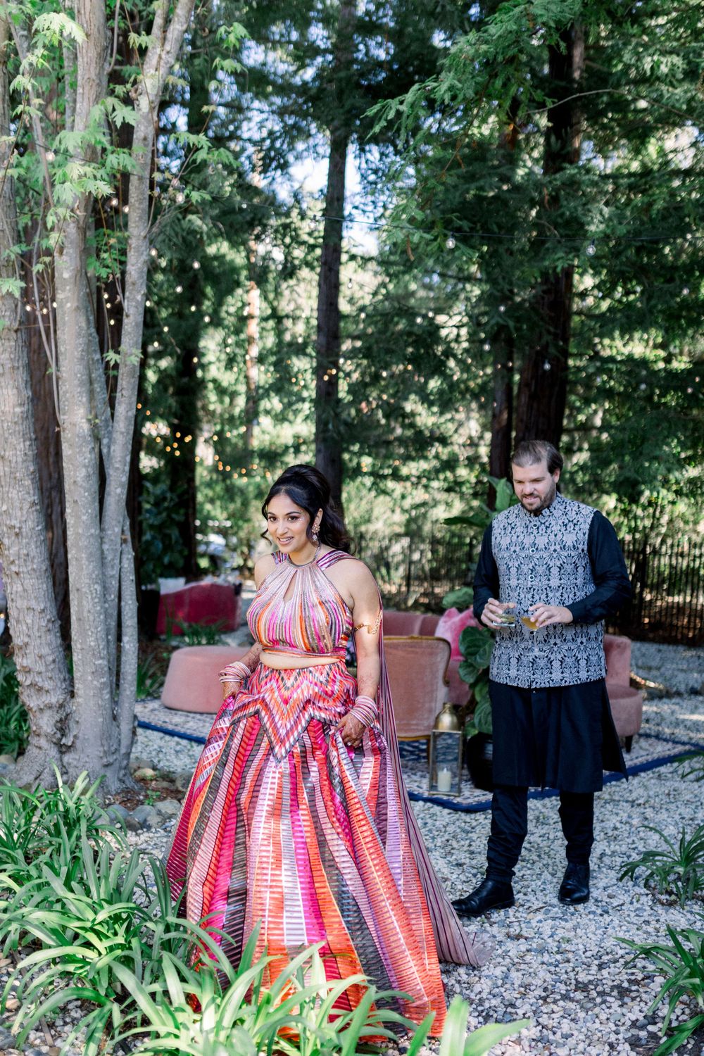Couple in coordinated outfits sharing sweet moments in a wooded outdoor setting.