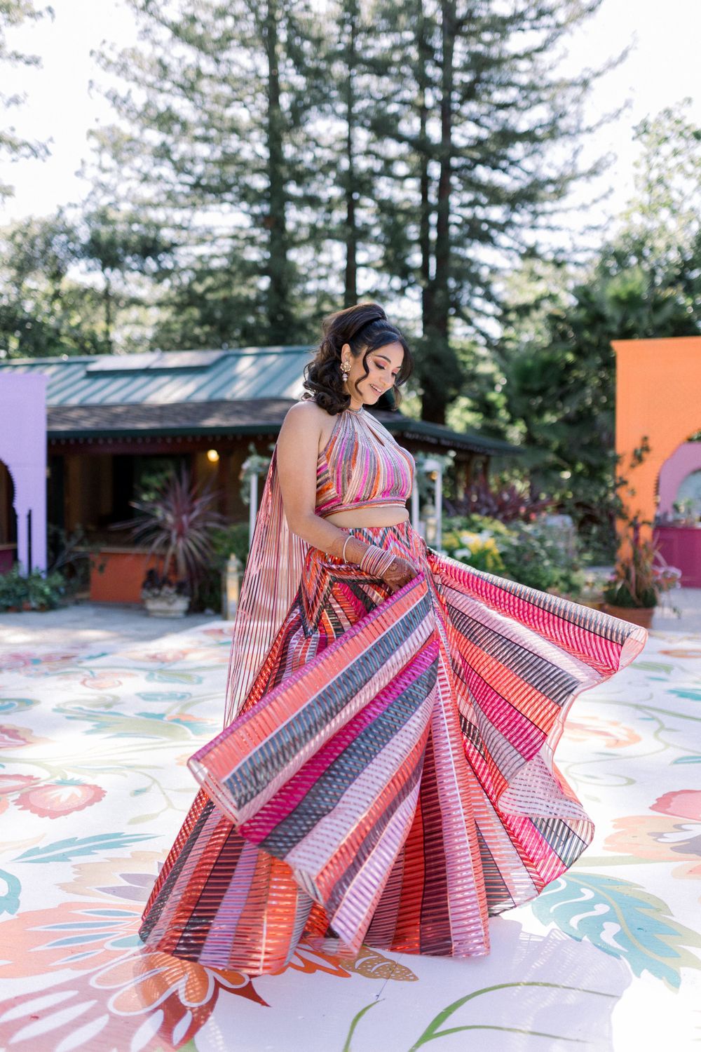 A stunning pink and white striped ballgown swirls on an outdoor dance floor with floral designs.