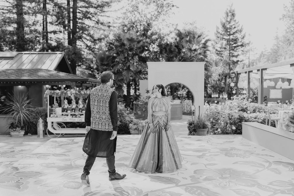 Black and white outdoor event photo showing trees and party structures.