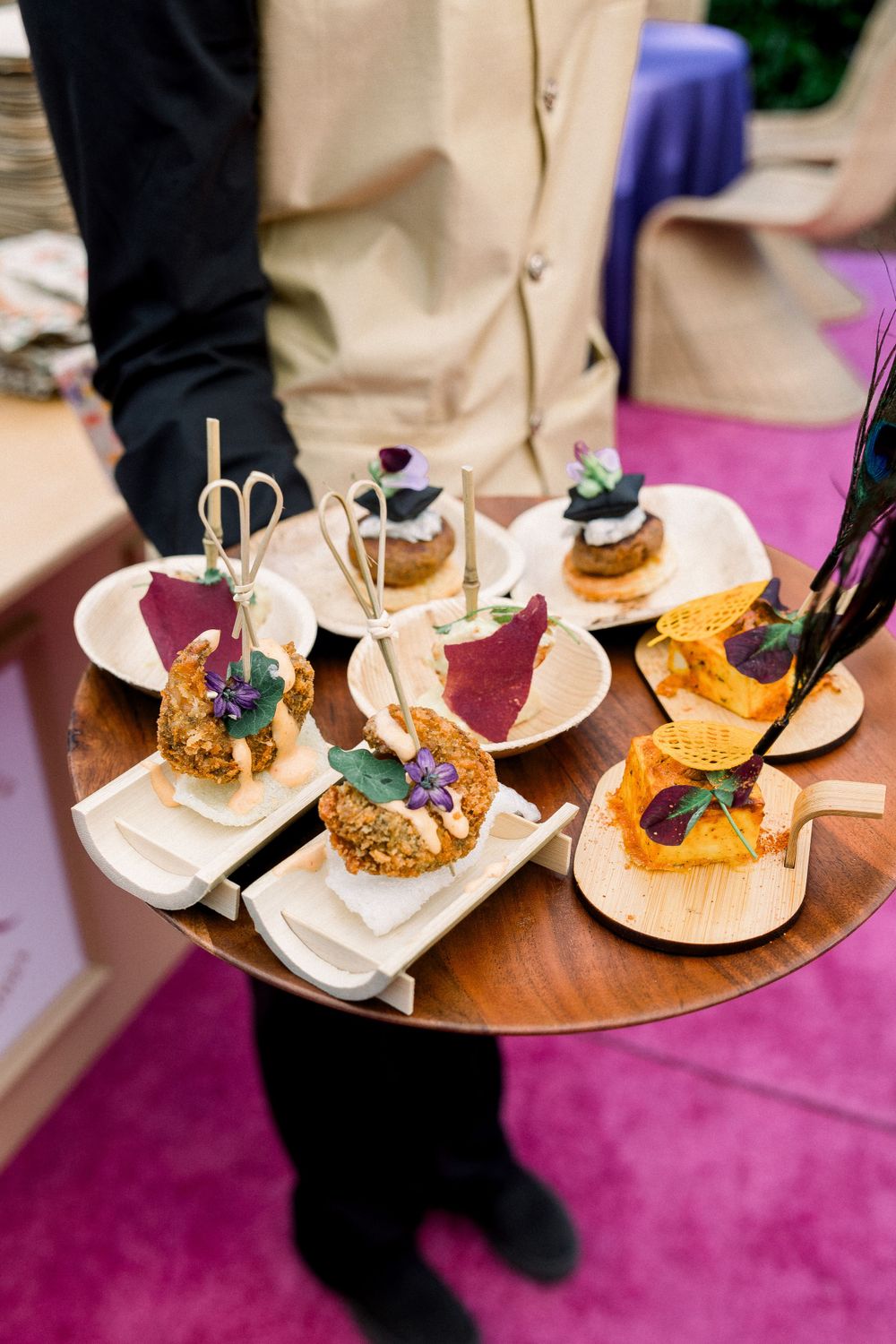 Elegant appetizers being served on white plates with decorative garnishes.