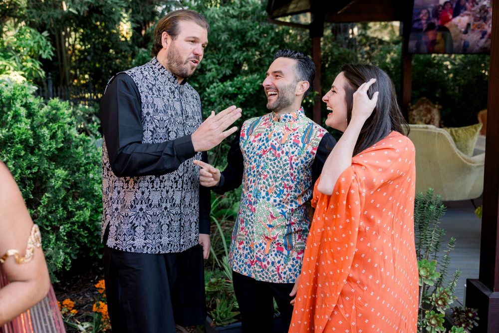 Guests mingling at an outdoor celebration with colorful decor and natural greenery.