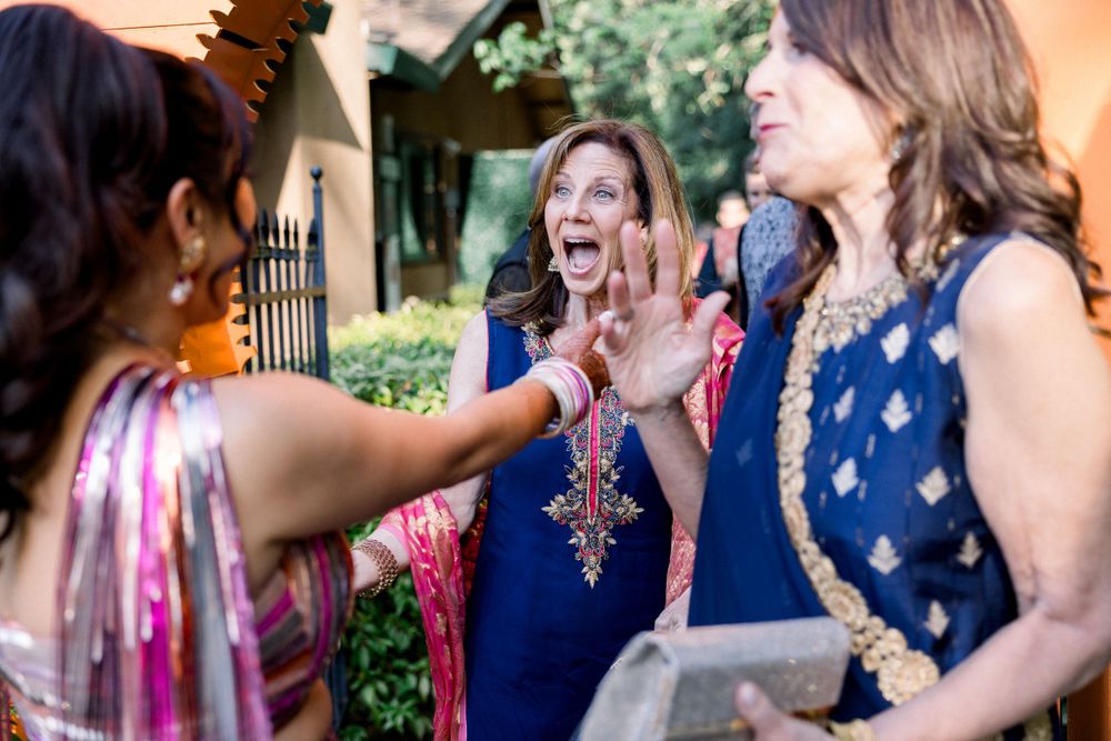 Party guests socializing and laughing at an outdoor celebration.