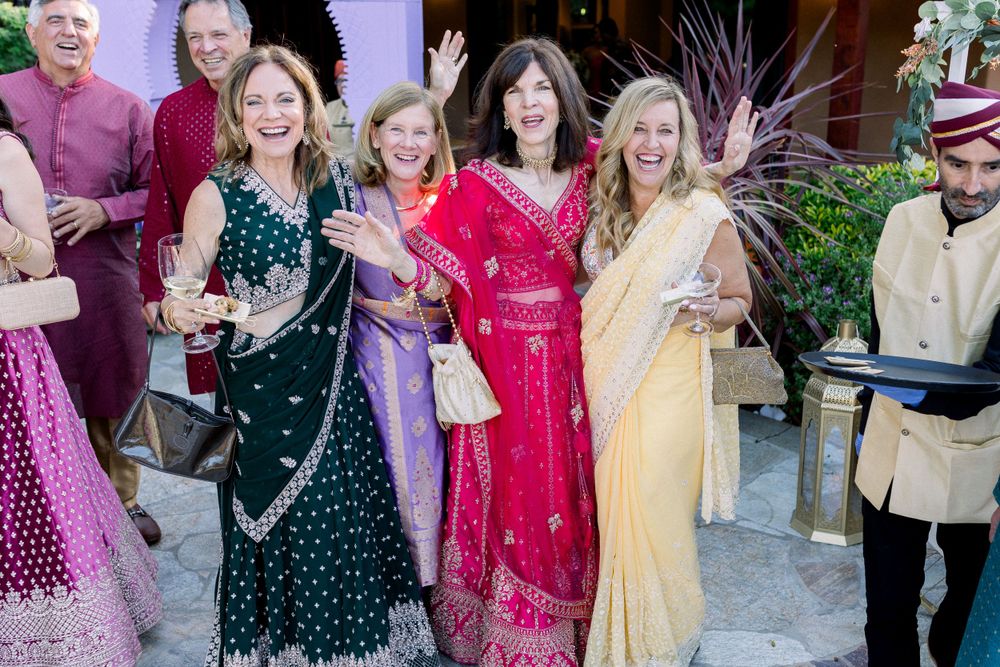 Celebratory outdoor party scene with guests in colorful attire.