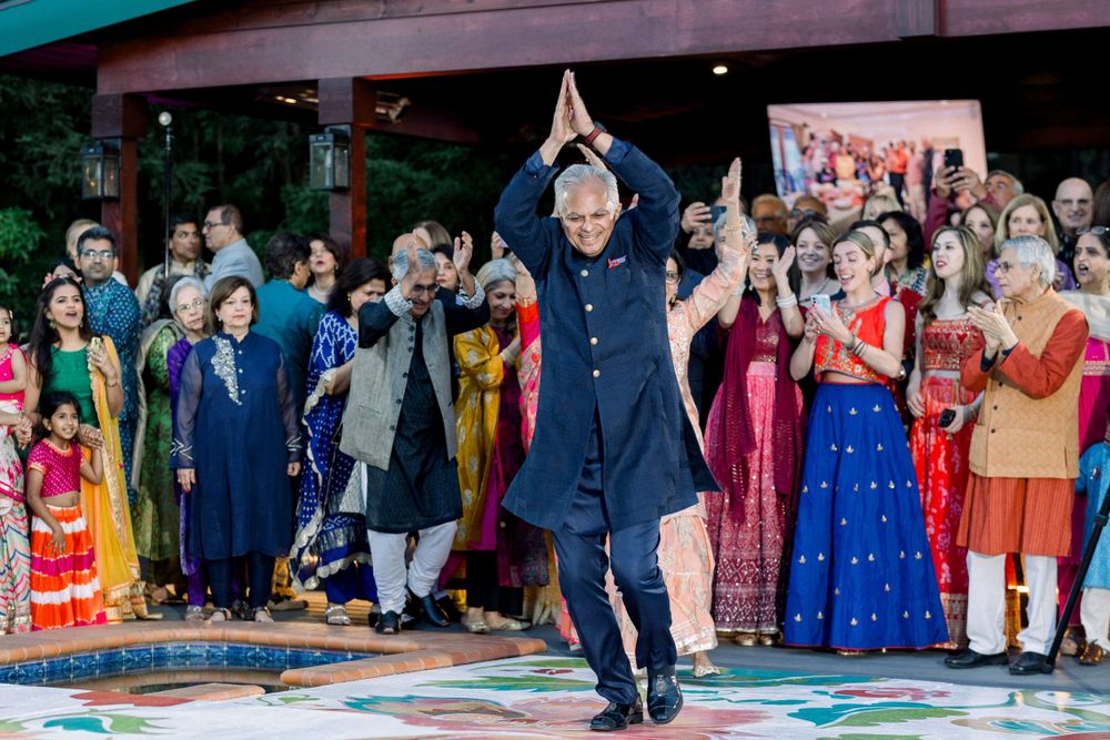 Celebratory dance performance on a colorful painted floor at a cultural event.