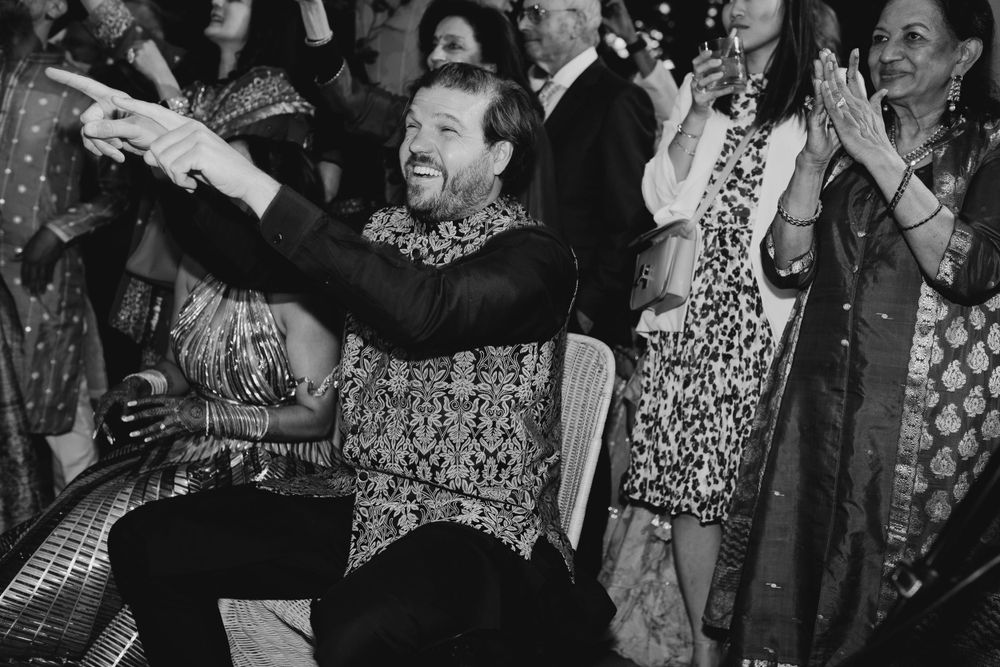 Large group of guests dancing together at a festive celebration with colorful attire.