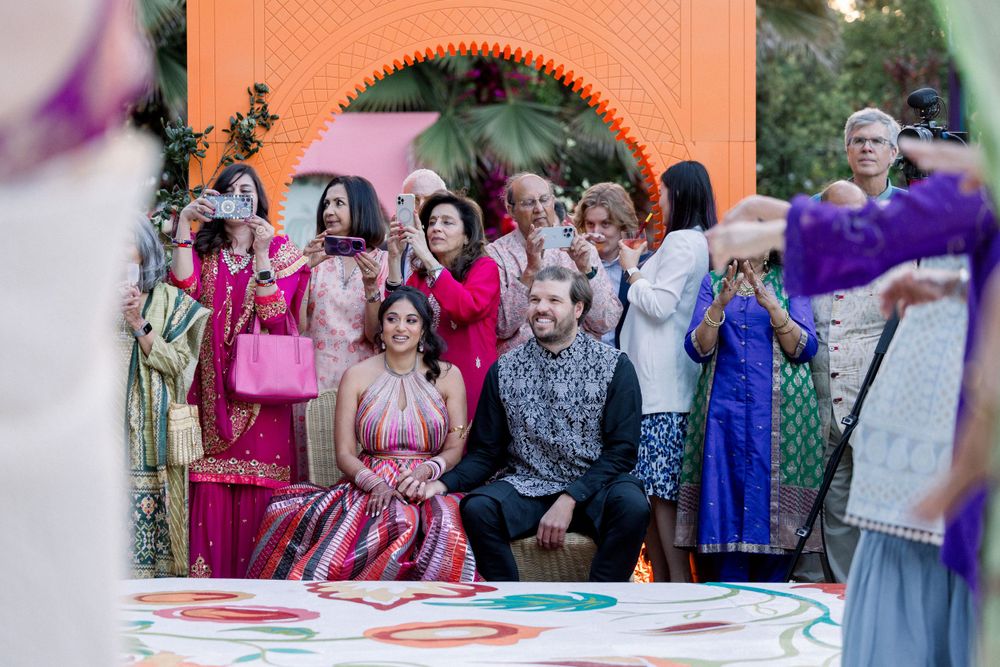 Outdoor wedding reception with guests dancing on a decorated patio space.