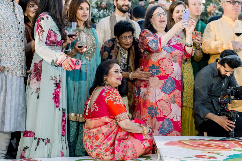 Wedding celebration featuring guests in colorful traditional attire dancing together.