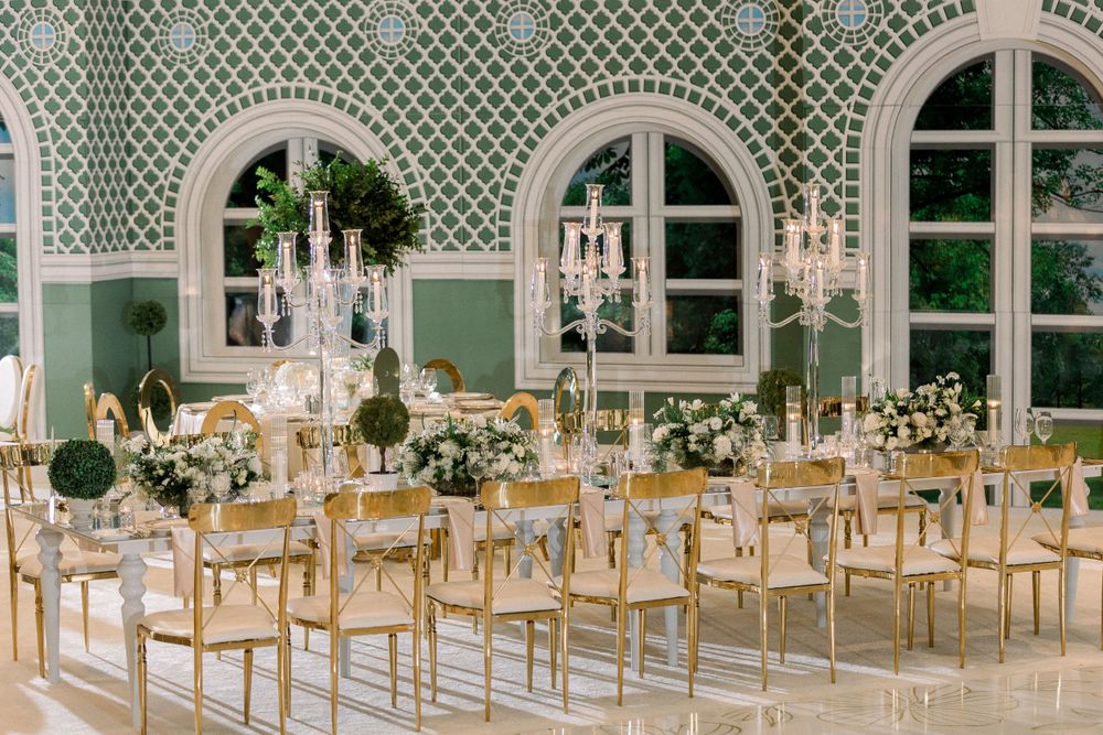 Elegant wedding reception venue with crystal chandeliers and gold chiavari chairs.