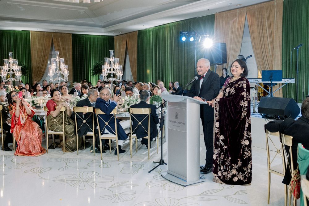 Formal event venue setup with green drapery and elegant chandelier lighting.