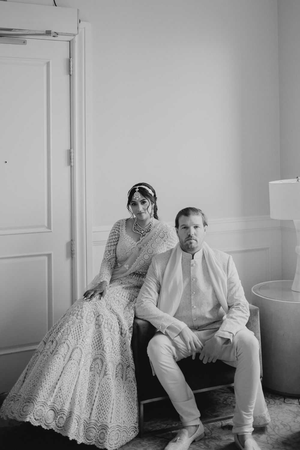 A couple poses in a romantic black and white portrait session wearing formal attire.