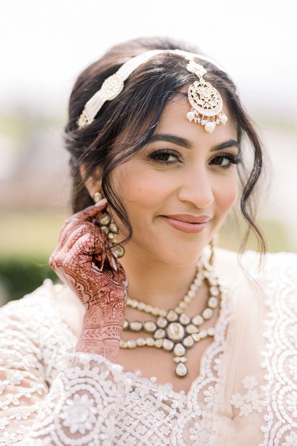 Close-up bridal portrait showcasing traditional Indian jewelry and intricate lace details.