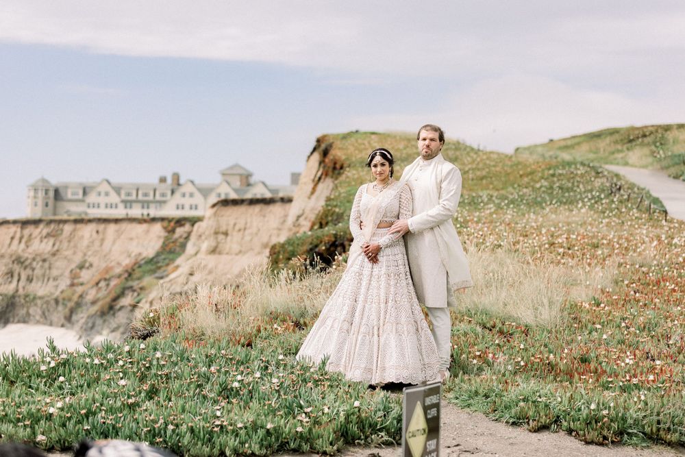 Couple walking along a scenic coastal path with dramatic cliffs and ocean views.