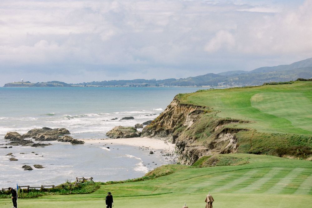 Stunning coastal landscape with rolling green hills and rocky cliffs meeting the ocean.
