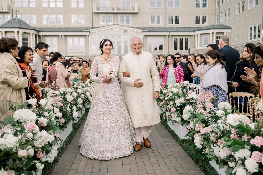 Outdoor wedding ceremony setup with floral aisle decorations and seated guests.