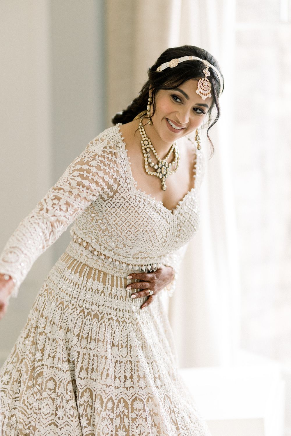 Bride twirls in an intricately detailed white lace wedding gown.
