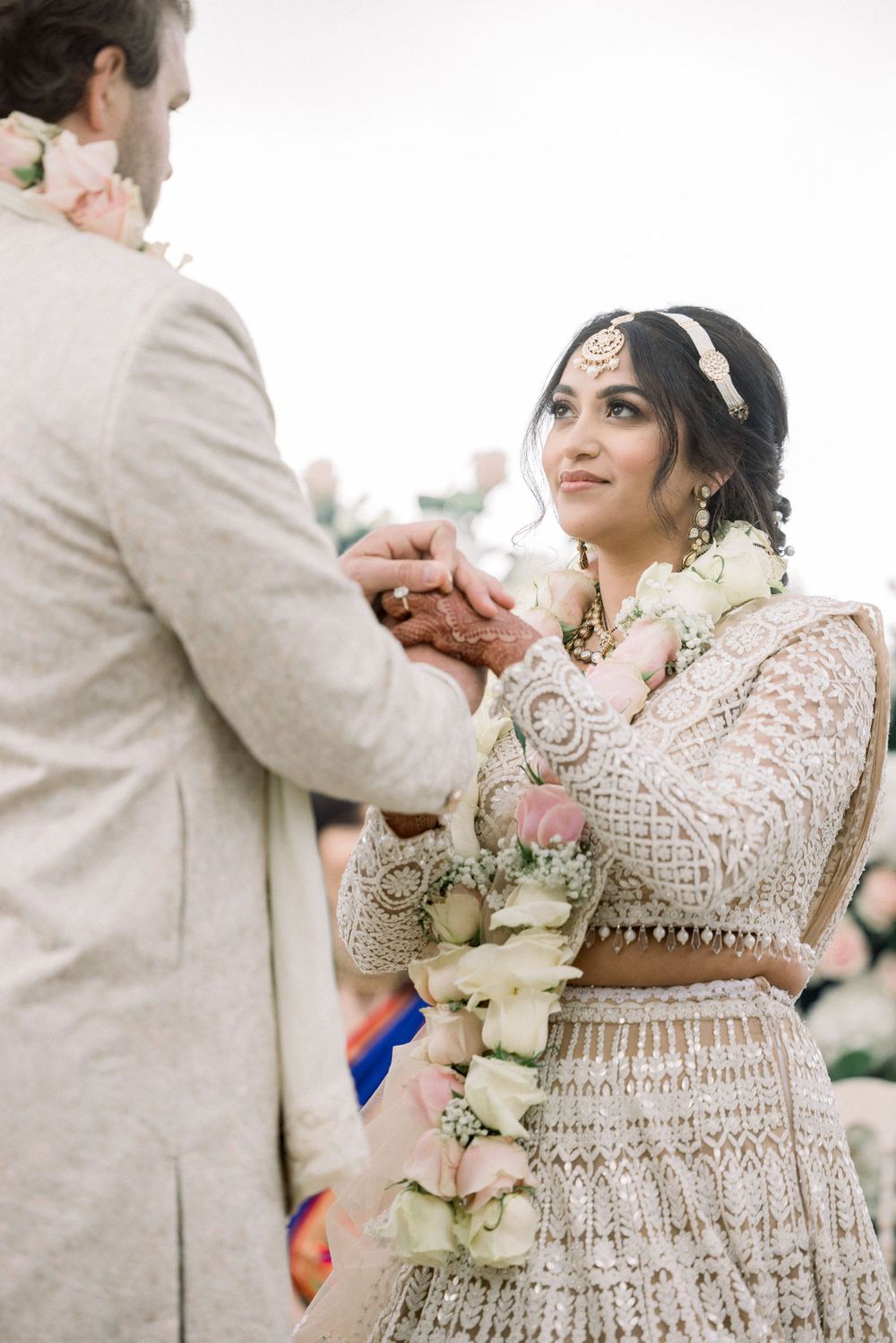Intimate moment during wedding ceremony with floral garland exchange.