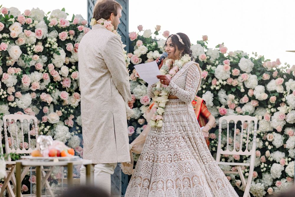 Traditional ceremony taking place against backdrop of pink and white roses.