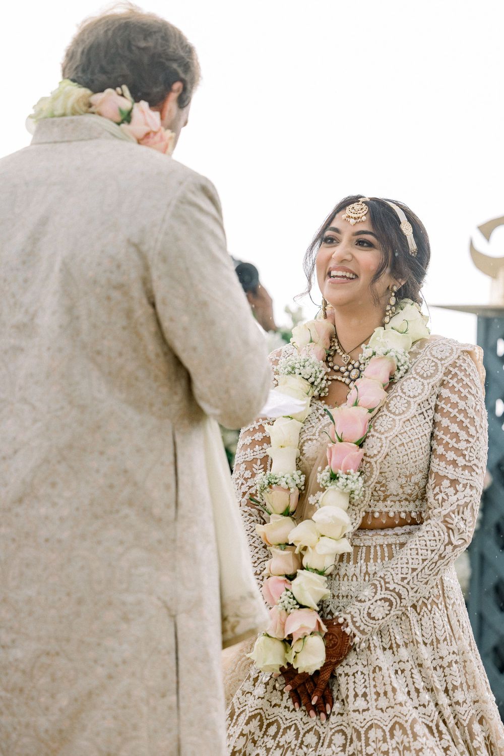 Wedding couple exchanging floral garlands during traditional ceremony.