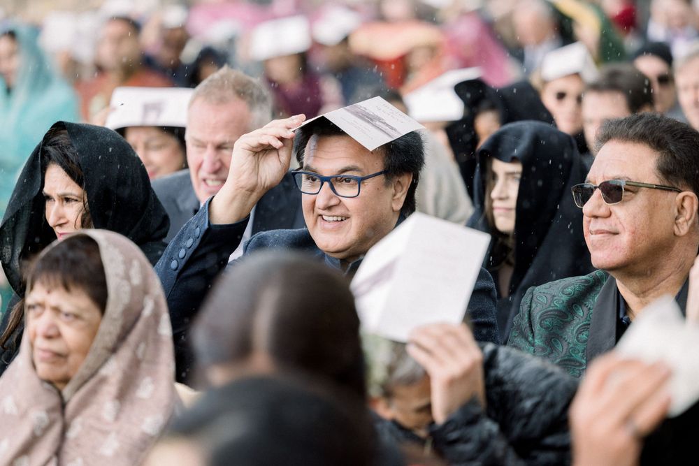 Wedding guests watching ceremony from seats with joyful expressions.