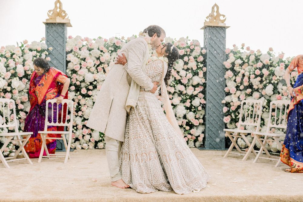 Traditional South Asian wedding ceremony with rose floral wall backdrop and elegant decor.
