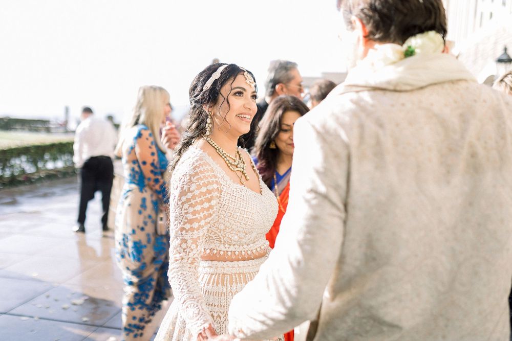 Wedding celebration with guests dancing and celebrating in formal attire outdoors.