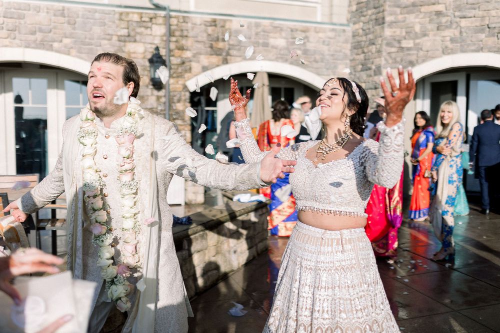 People celebrating and dancing at a formal event in front of a stone building.