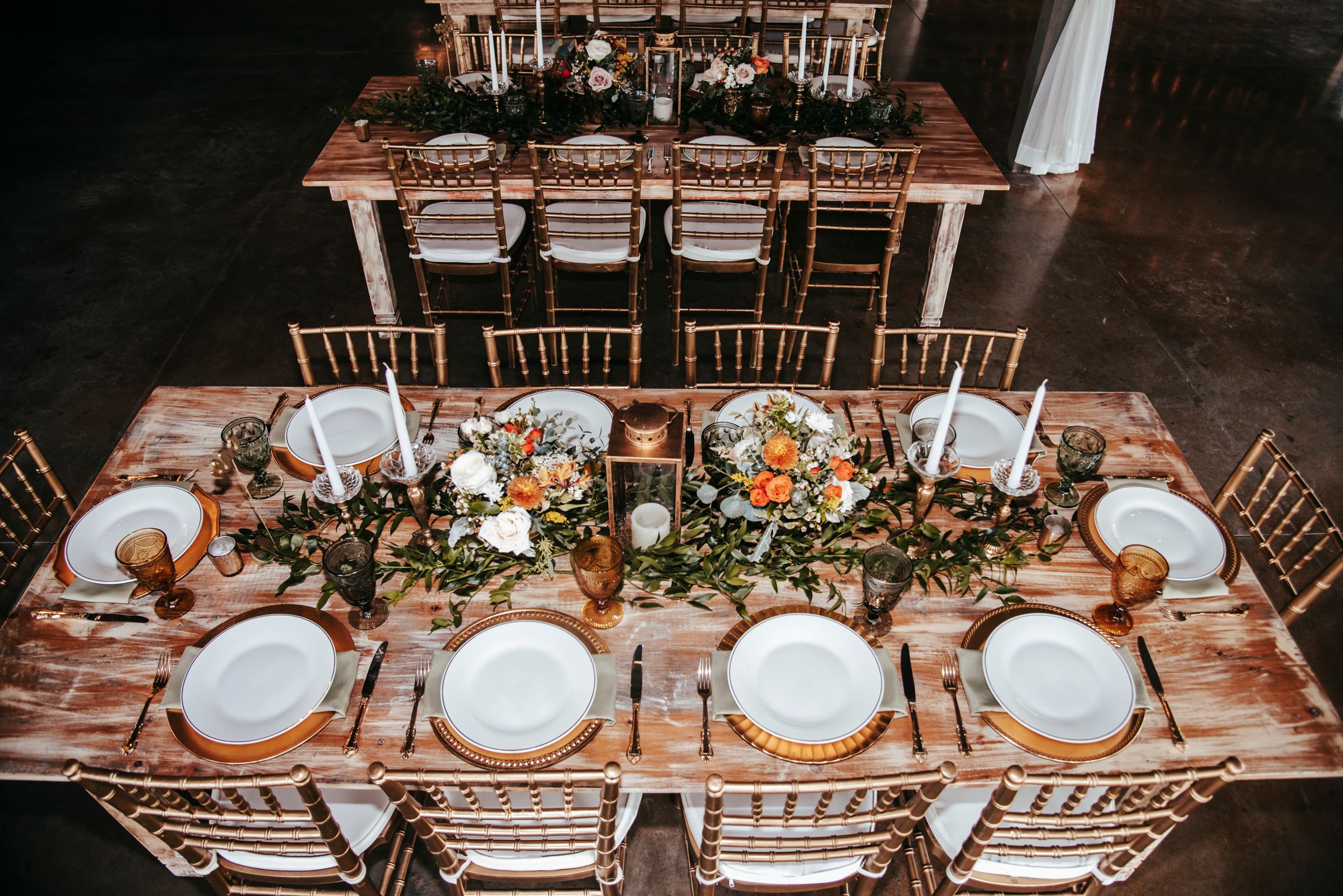 An overhead view of an elegantly decorated wedding reception table with floral centerpieces.