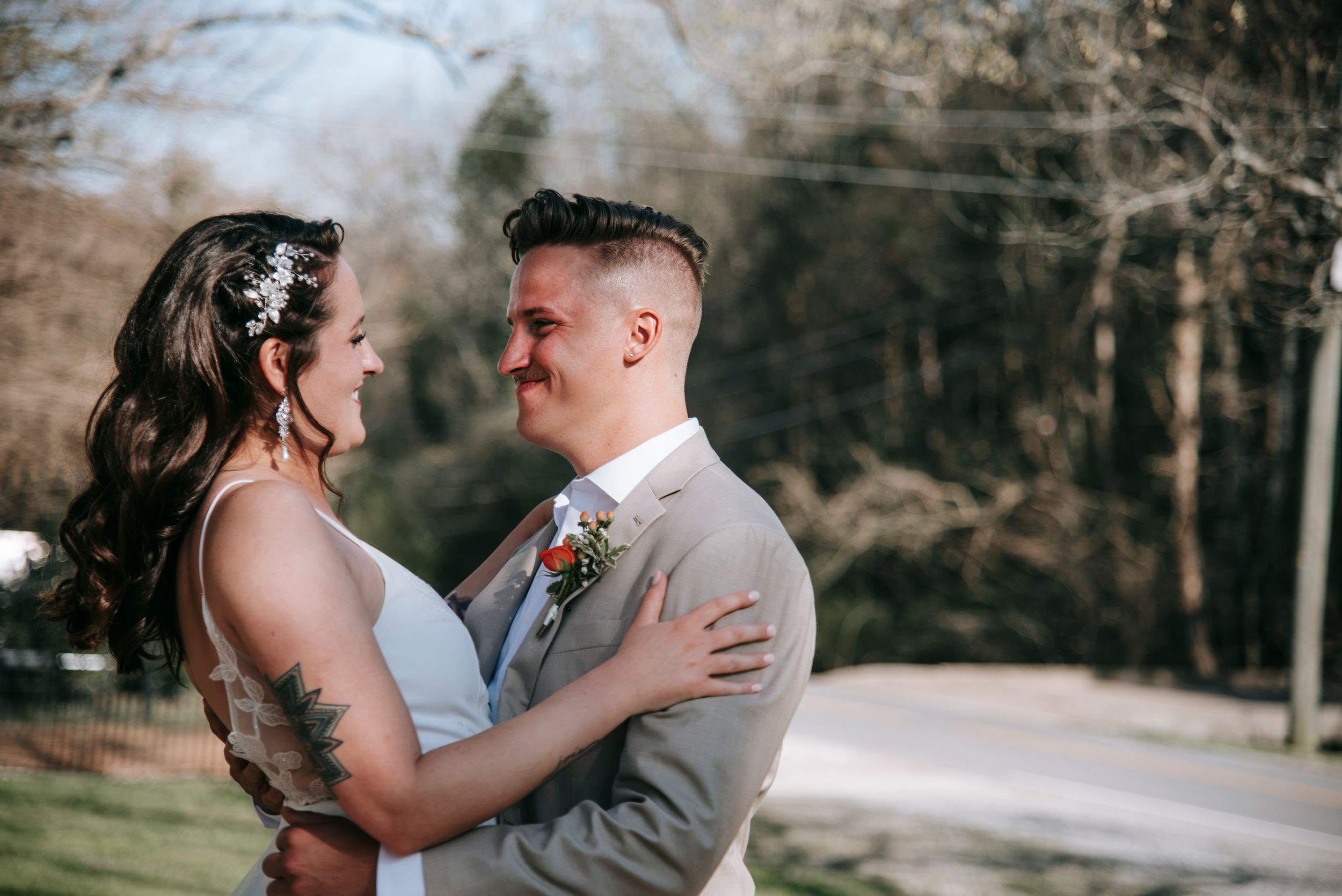 Newlyweds embrace outdoors during winter wedding photoshoot.