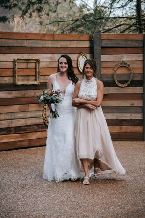 Elegant wedding photo against wooden wall with decorative frames.