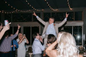 Wedding reception celebration with guests dancing under string lights.