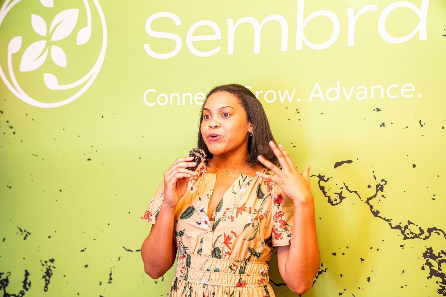 Woman posing against lime green Sembra branded wall.