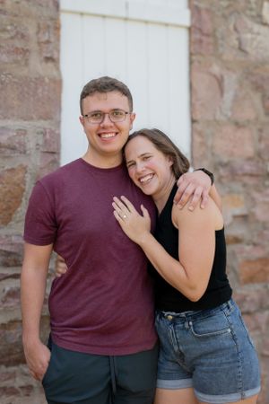 A newly engaged couple smiling and hugging each other.