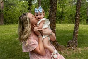 A mom kissing her baby on the cheek