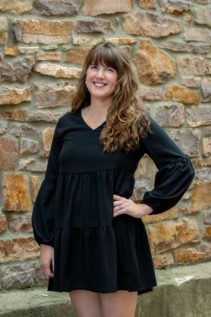 A young professional woman wearing a black dress.