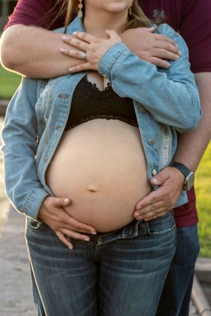 A couple holding the wife's pregnant belly.