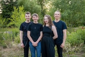 4 young adult siblings smiling at the camera.