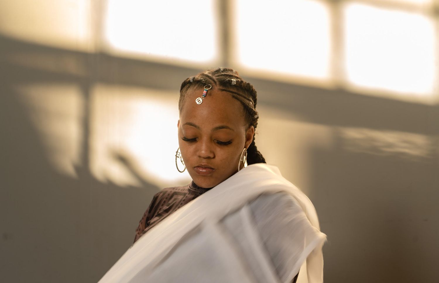 Person in white clothing photographed in warm sunlit interior space.