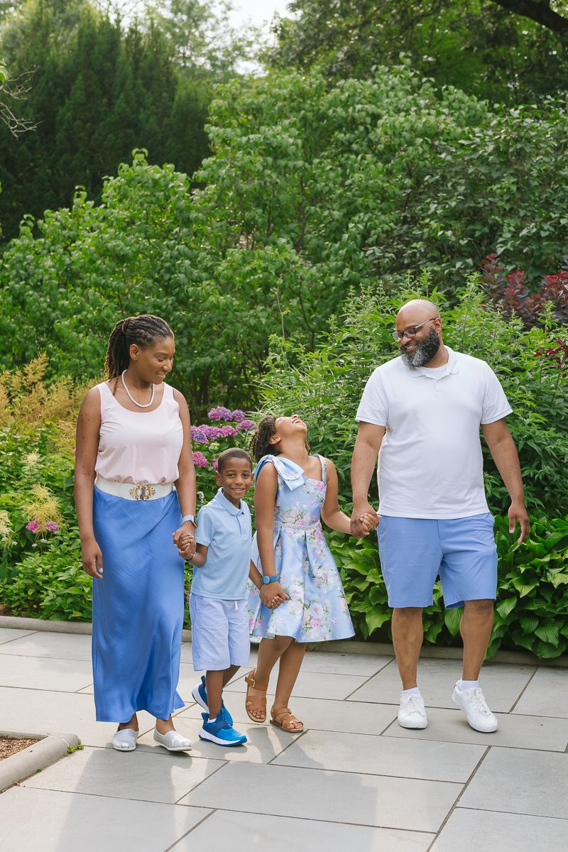 Family of four laughing together while strolling Central Park, captured by Paula Brearley
