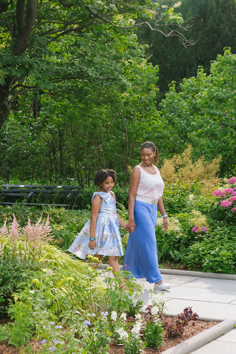 Mom and daughter holding hands strolling through Central Park garden