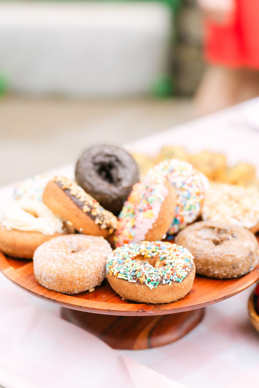 Elegant spread of seasonal fruit and pastel-glazed doughnuts on a garden party table in soft morning light