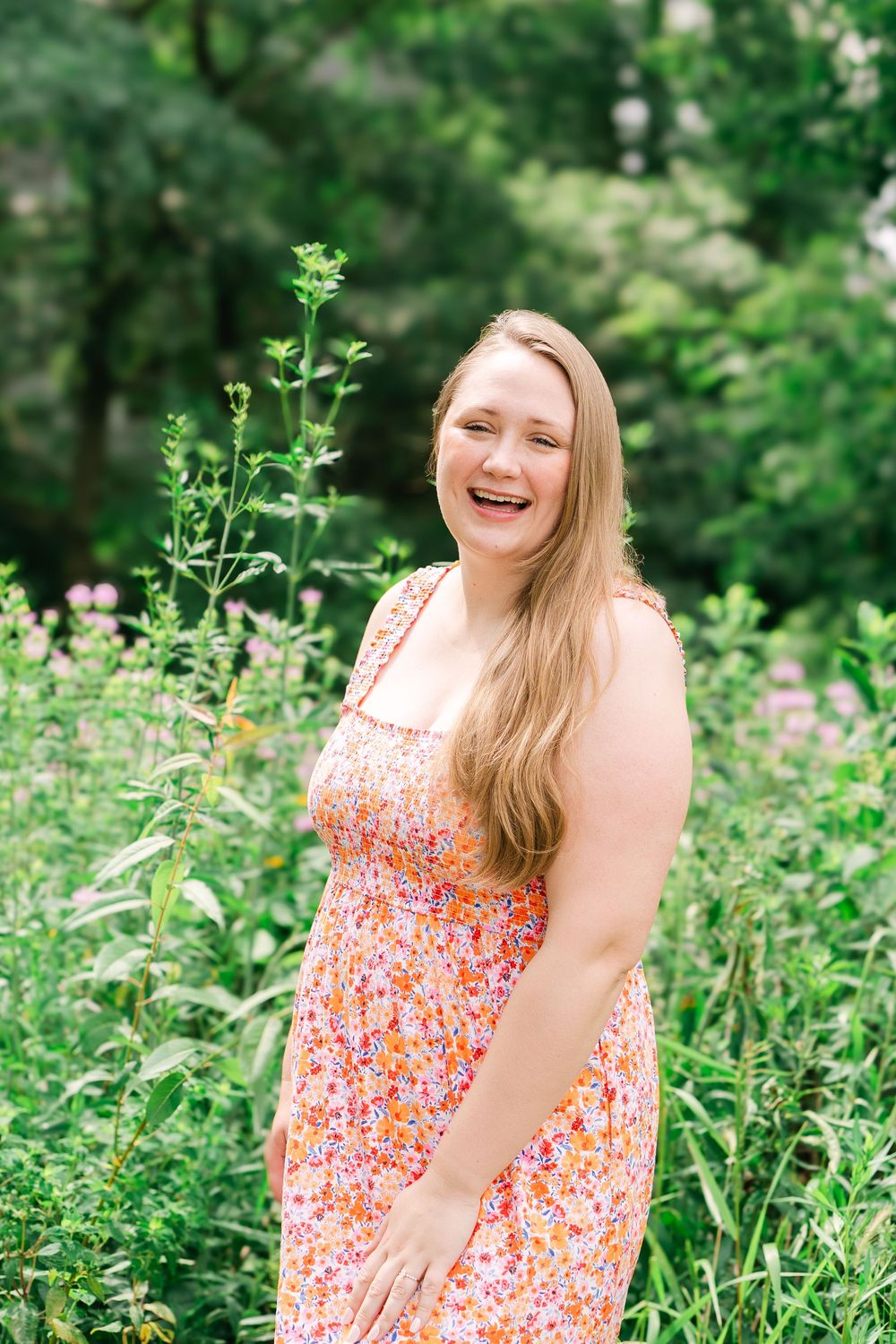 Natural portrait of bride-to-be smiling softly in a sunlit outdoor setting