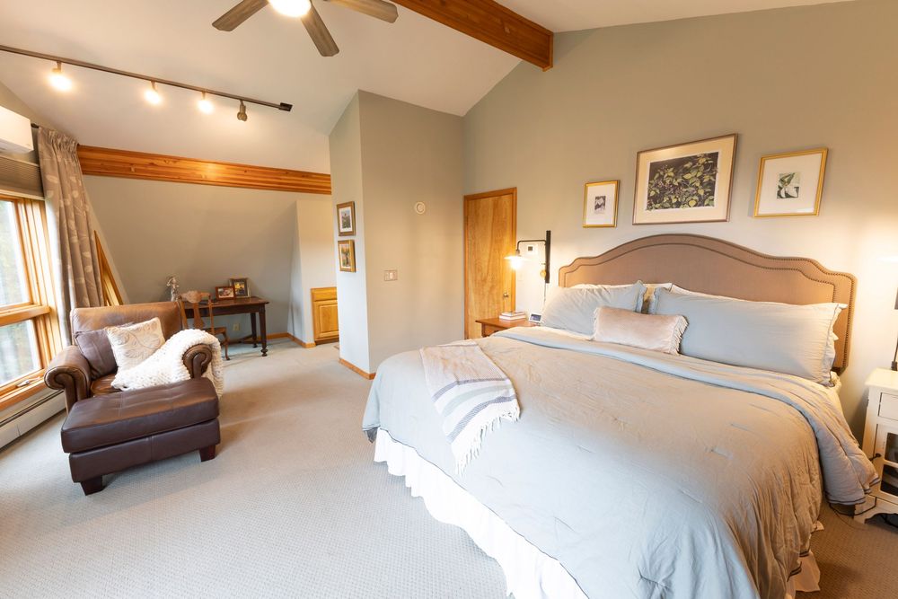 Bedroom with sloped ceiling and natural light shown from different perspectives.