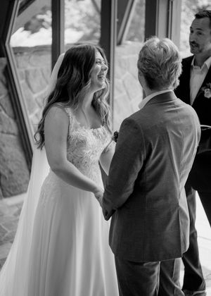 A black and white wedding ceremony moment captured in a bright architectural setting.