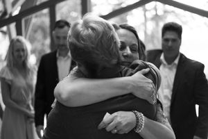 Black and white photos showing emotional embraces during wedding celebrations.