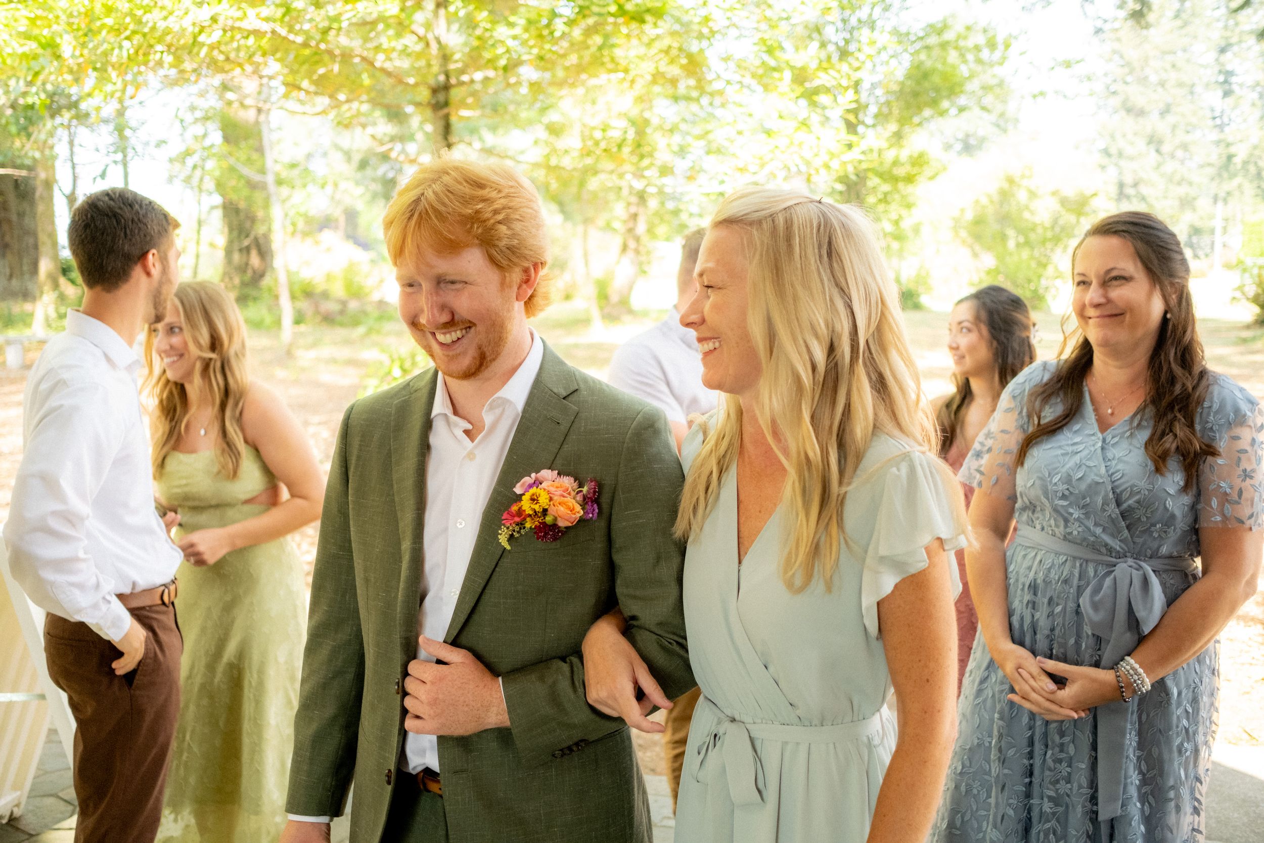 Wedding guests gather in natural light for celebration photos.